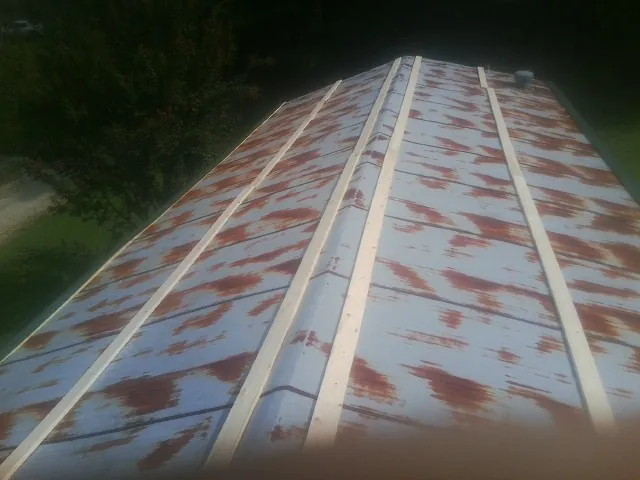 Rusted metal roof panels with new wood purlins before replacement — Storm Damage Roof Repair in Penhook by Roofing Brothers